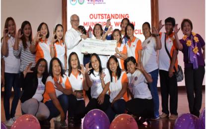 <p><strong>BATANGAS OUTSTANDING WOMEN.</strong> These empowered women from the town of Cuenca flash their “C” hand sign while receiving the huge ceremonial check worth PHP 200,000 and the plaque of recognition from Batangas Gov. Hermilando Mandanas (in barong), during the Women’s Month celebration at the Provincial Capitol auditorium on March 23. Cuenca's Municipal Women Coordinating Council (MWCC) was adjudged as Batangas province’s “Most Outstanding” MWCC <em>(PNA photo courtesy of Batangas PIO)</em></p>